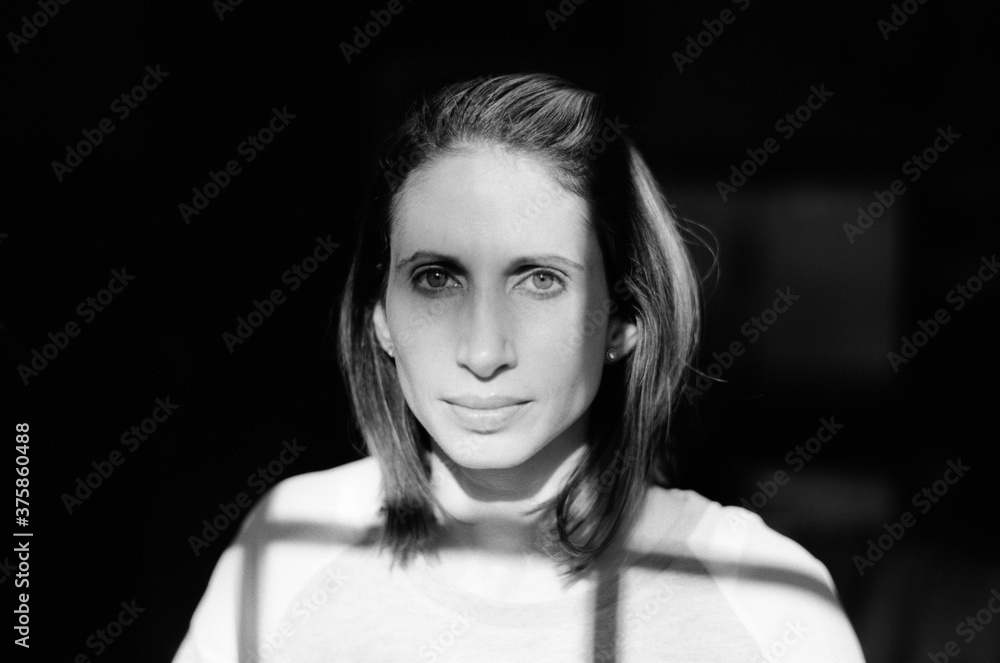 Black and white portrait of a woman with shadow from window Black and white portrait of a woman with shadow from window