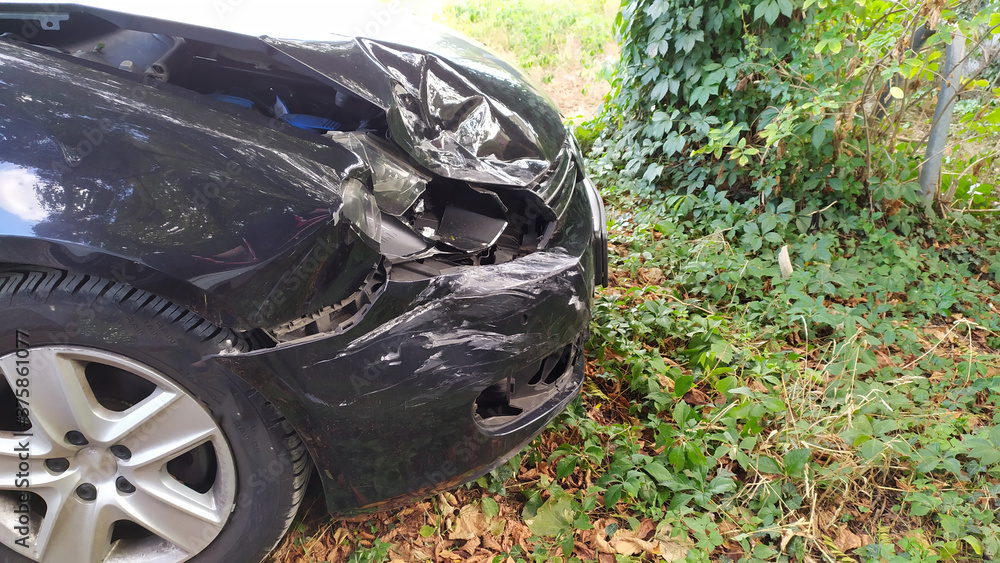Crashed car with a destroyed front and car engine hood shows misfortune and the need for car insurance to avoid financial total loss and collision safety or repair after collision and emergency Crashed car with a destroyed front and car engine hood shows misfortune and the need for car insurance to avoid financial total loss and collision safety or repair after collision and emergency