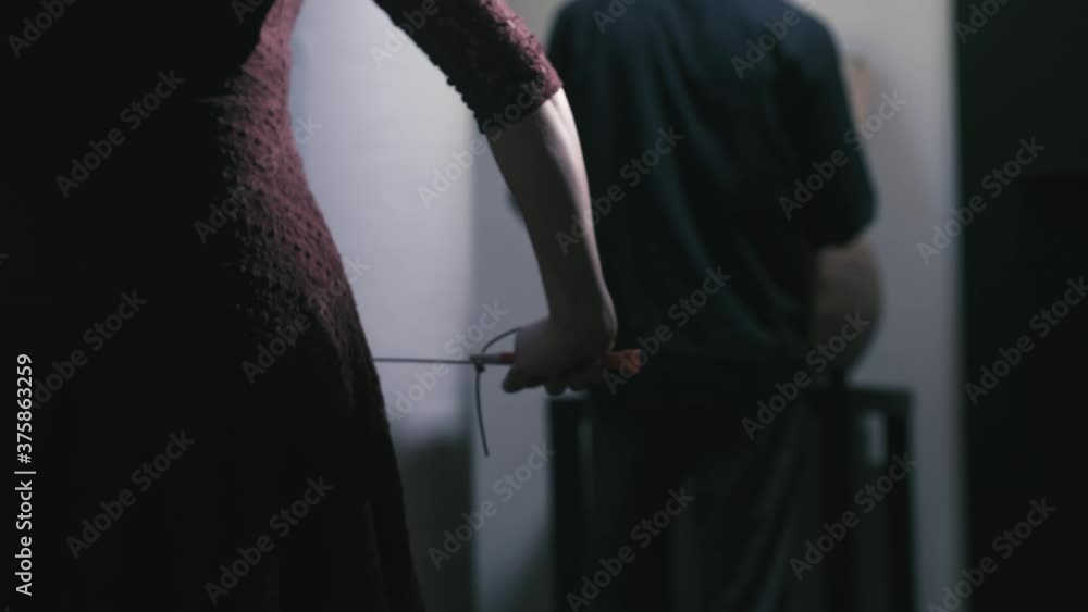 Woman tightening garrote jump rope approaching man target from behind ...