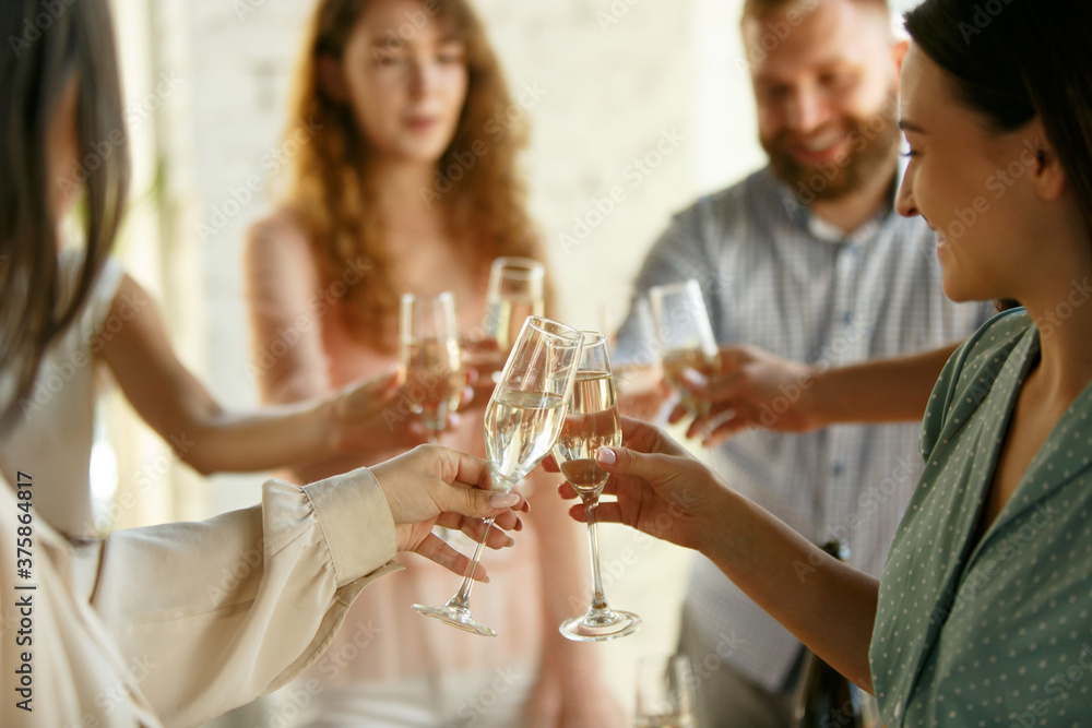 Happiness. People clinking glasses with wine or champagne. Happy cheerful friends celebrate holidays, meeting. Close up shot of smiling friends, lifestyle. Party at home or in restaurant, cafe.