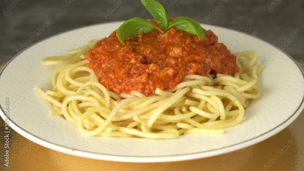 Traditional pasta bolognese served on a white plate and garnished with basil Close up Traditional pasta bolognese served on a white plate and garnished with basil Close up