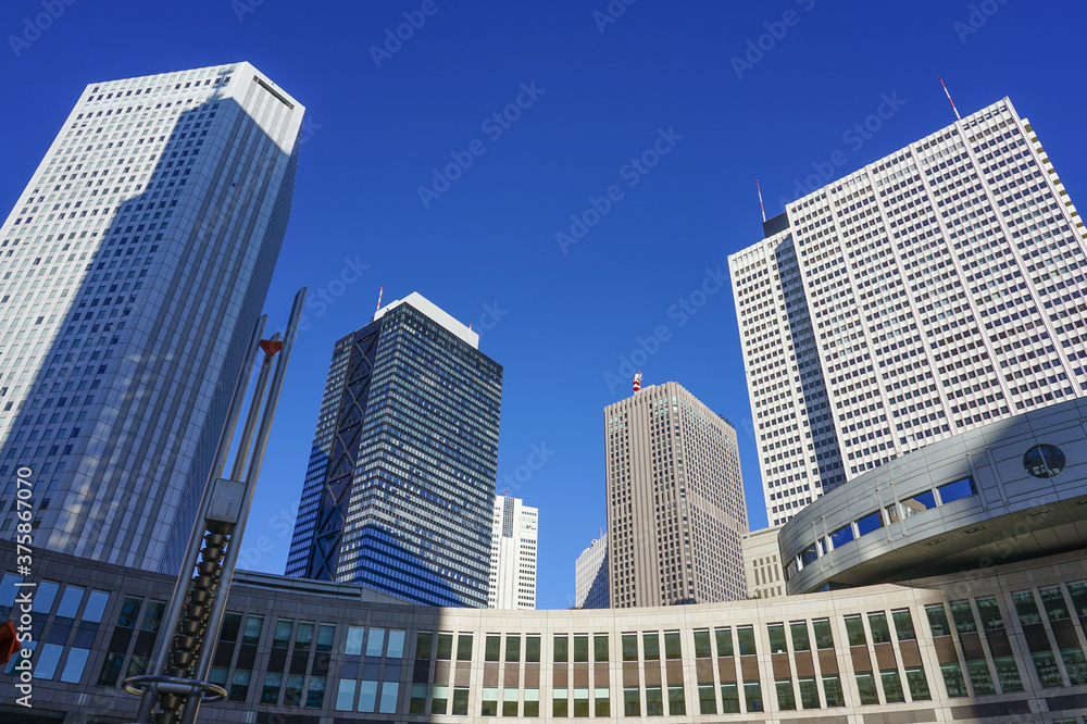 青空を背景に東京都議会議事堂と新宿超高層ビル群のスカイライン