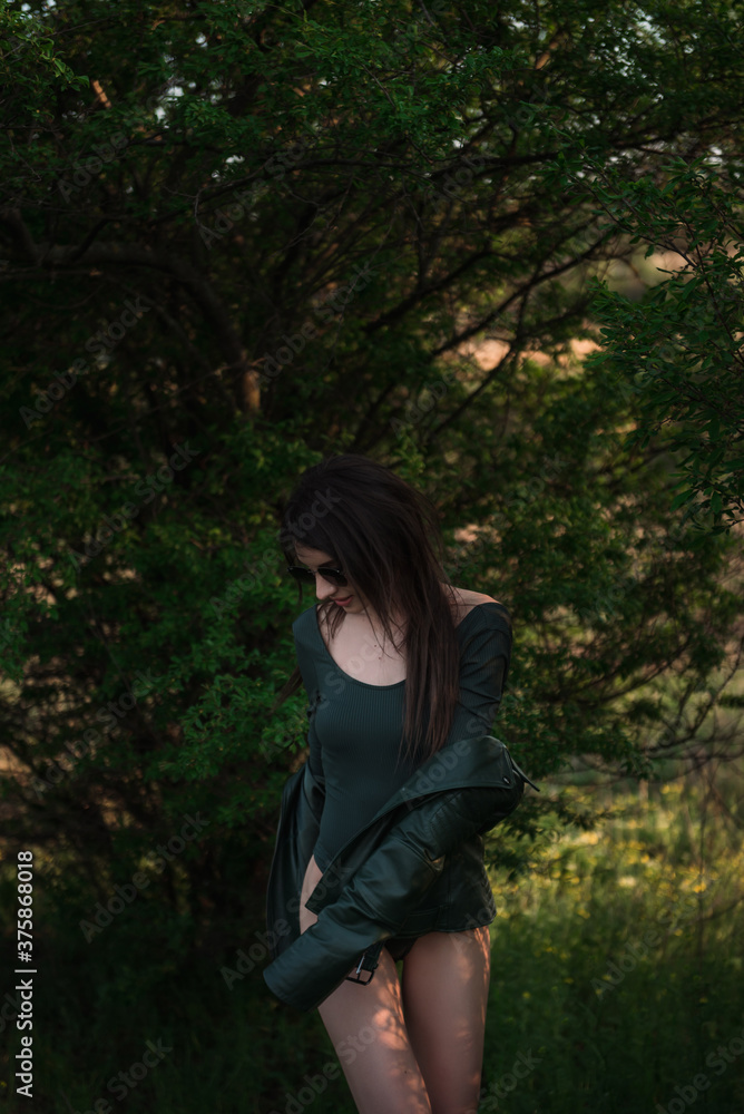 Portrait of charming dark hair woman in green bodysuit and leather jacket Portrait of charming dark hair woman in green bodysuit and leather jacket