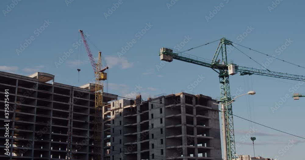 Crane and building under construction against blue sky Crane and building under construction against blue sky
