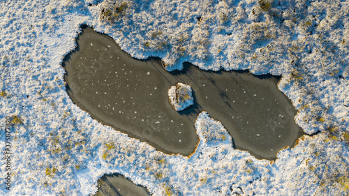 Fotografía Aerial view over winterly snow and ice-clad peat bog landscape in natural Estoni
