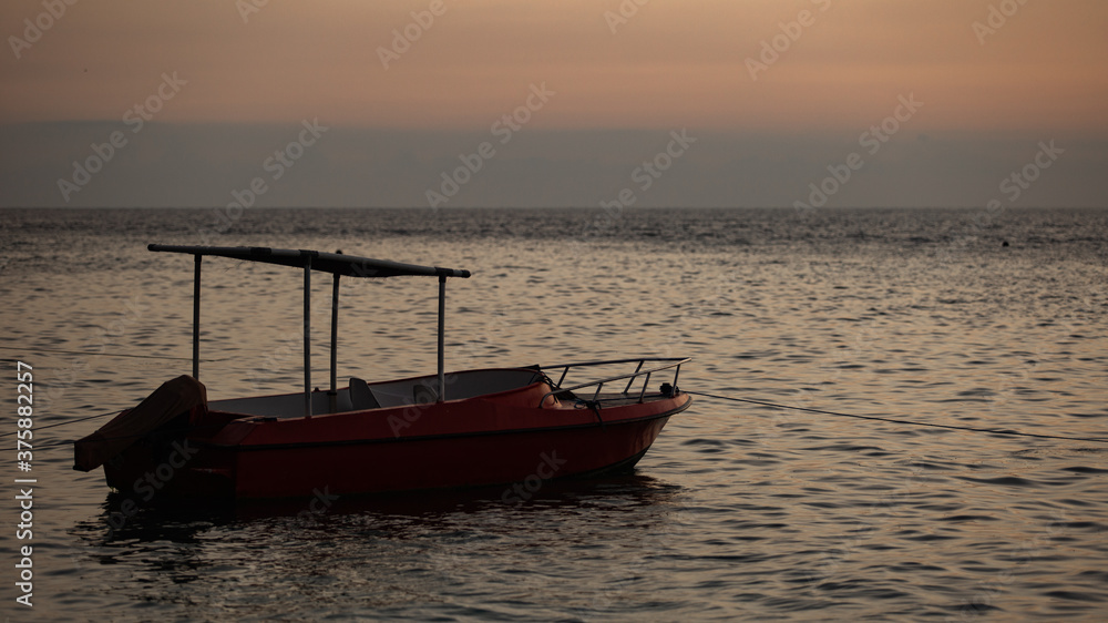small boat floats on the water against the background of mountains