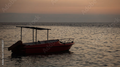 small boat floats on the water against the background of mountains