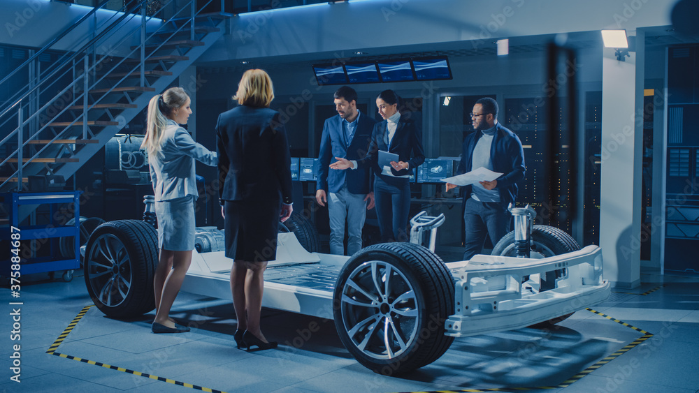 Diverse Team of Automobile Design Engineers Introducing Futuristic Autonomous Electric Car Platform Chassis to a Group of Investors and Businesspeople. Vehicle Frame with Wheels, Engine and Battery
