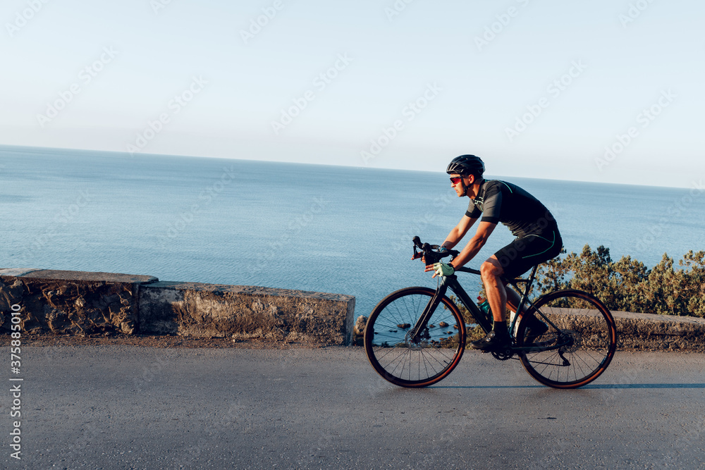 Fototapeta premium Jazda na rowerze sportowiec mężczyzna na nadmorskiej drodze
