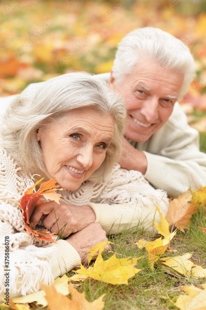 Portrait of beautiful senior couple lying on grass Portrait of beautiful senior couple lying on grass