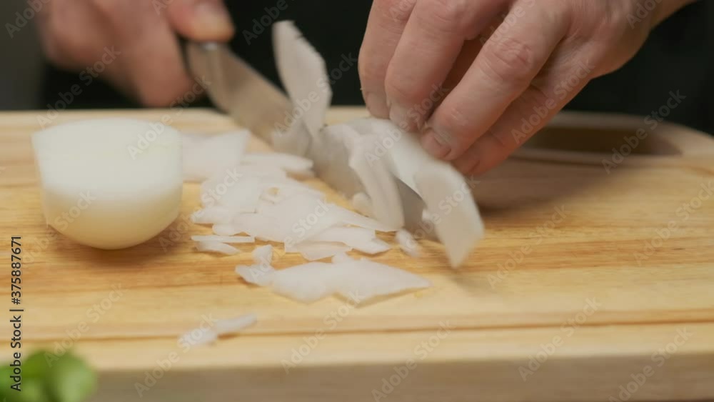 Professional chef prepares and cuts white onion. Close up slow motion Professional chef prepares and cuts white onion. Close up slow motion