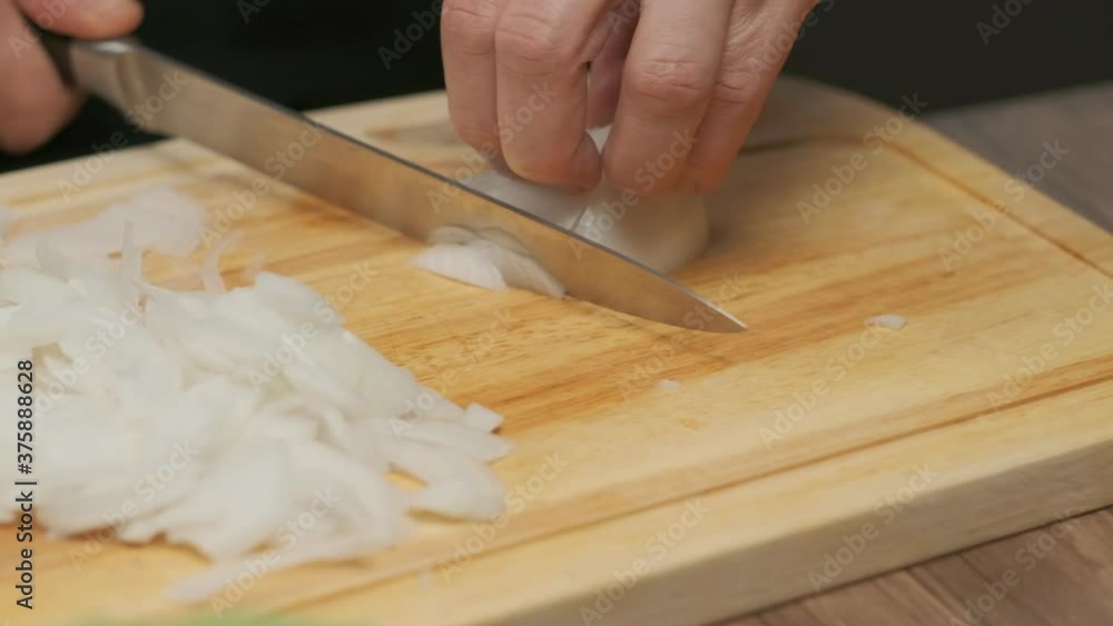 Professional chef prepares and cuts white onion. Close up slow motion Professional chef prepares and cuts white onion. Close up slow motion