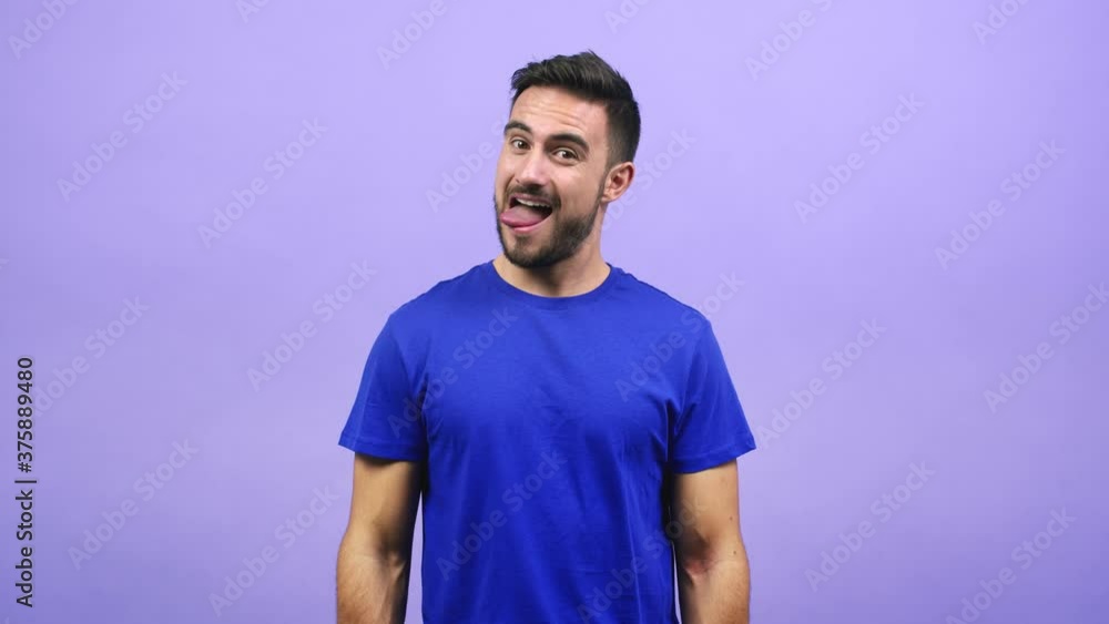 Young caucasian man expression of confidence and emotion, fun and friendly, showing tongue as a sign of play or fun Young caucasian man expression of confidence and emotion, fun and friendly, showing tongue as a sign of play or fun