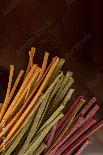 Dry pasta of different colors, yellow with turmeric, pink with storm, green with spinach, Italian cuisine, telanatelle