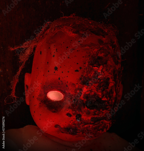 Creepy bloody doll Halloween concept, Close up of children Ghost mystic doll, Scary horror doll face isolated on black background. photo