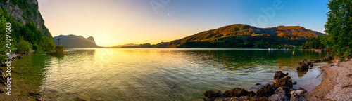 Kreuzstein am Mondsee mit Drachenwand bei Sonnenuntergang Panorama