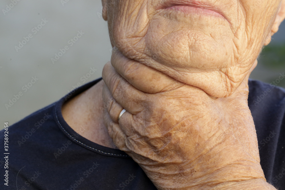 Elderly caucasian woman touching her throat. Sore throat, tonsillitis or thyroid gland problem. Elderly caucasian woman touching her throat. Sore throat, tonsillitis or thyroid gland problem.