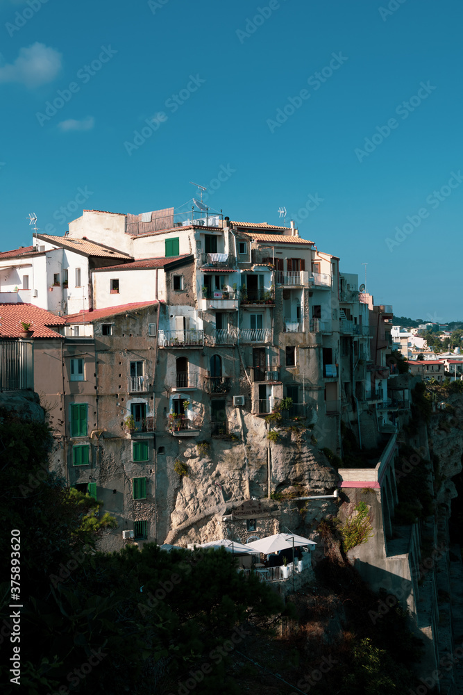 View from above of the vintage buildings of the city center of Tropea, famous touristic destination in the south of italy. Sea view, old discarded buildings and homes.