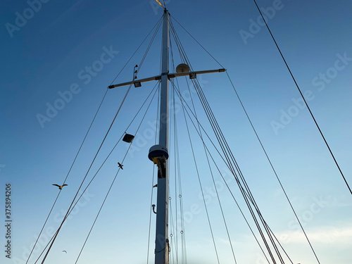 Upright view of rigging mast and ropes of a sailing boat under a blue sky