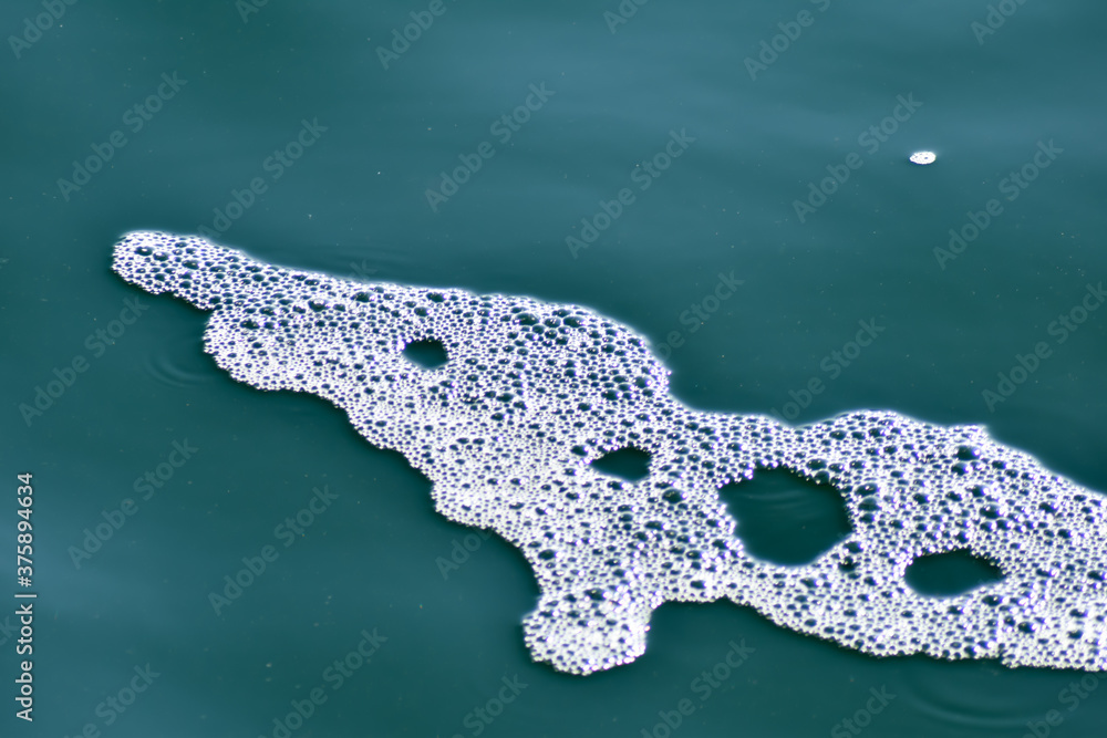 Obraz premium Biała piana na kolorowej wodzie.