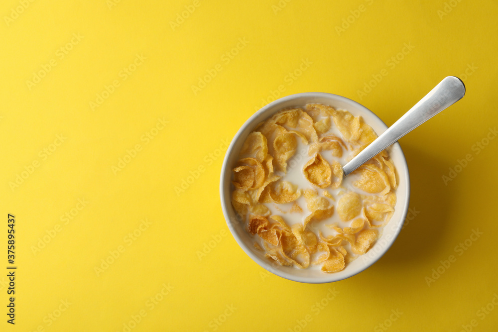Bowl with muesli and milk on yellow background