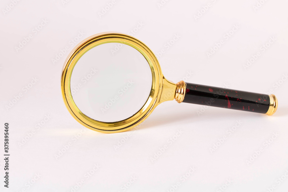 Old magnifying glass on a light background. Old magnifying glass on a light background.