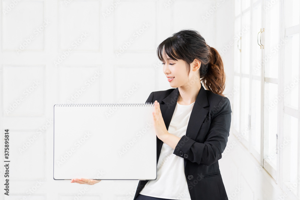 大きいスケッチブックを持つ若いビジネスウーマン