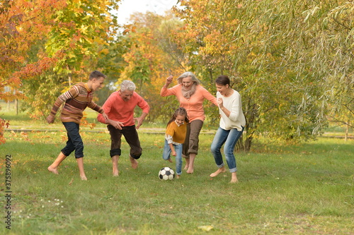 Fototapeta Big happy family playing football in park