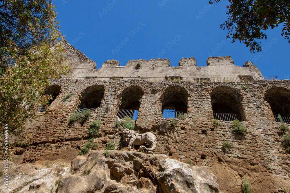 The castle with Lion fountain by Bernini in Ancient Monterano,with the Lion on top the wall, represented in the act of shaking the rock with a paw to make the water emanate. The castle with Lion fountain by Bernini in Ancient Monterano,with the Lion on top the wall, represented in the act of shaking the rock with a paw to make the water emanate.