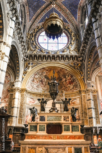 Great close-up view of the marble high altar with a big bronze Eucharistic tabernacle at the presbytery in the famous Siena Cathedral. The main altar was built in 1532 by Baldassarre Peruzzi.