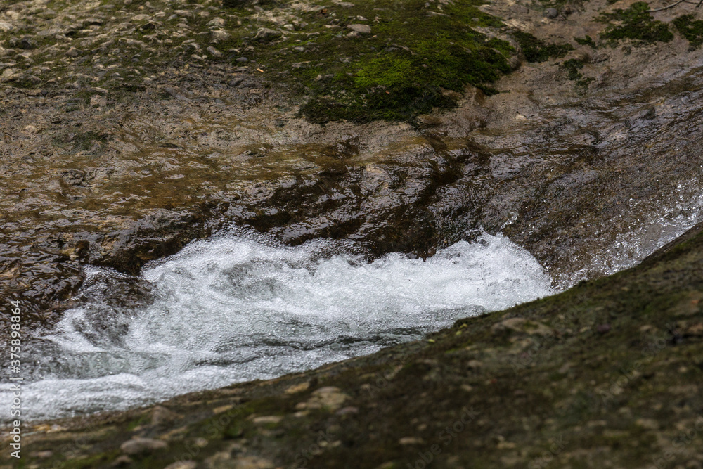 Foaming water at the waterfall of a mountain stream in Argentobel in Allgäu Foaming water at the waterfall of a mountain stream in Argentobel in Allgäu