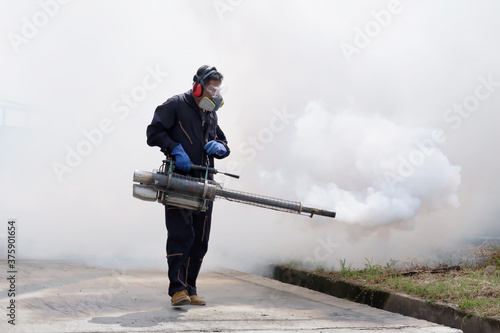 Принти на полотні Outdoor health workers in protective clothing using chemical fogging machines to kill mosquitoes