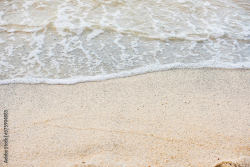 Soft beautiful ocean wave on sandy beach. Background. Sea wave on white sandy beach. Travel natural background. Soft focus