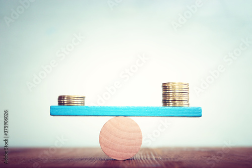 Stack of coins balance on seesaw