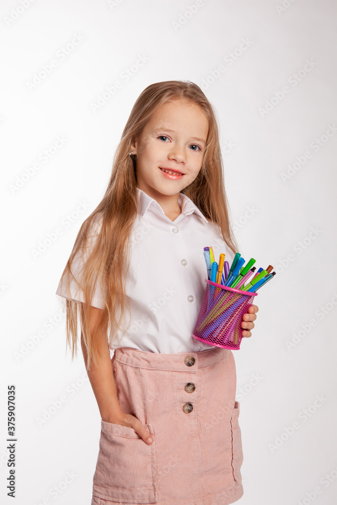 girl stands and holds a jar of felt-tip pens in her hands. girl stands and holds a jar of felt-tip pens in her hands.