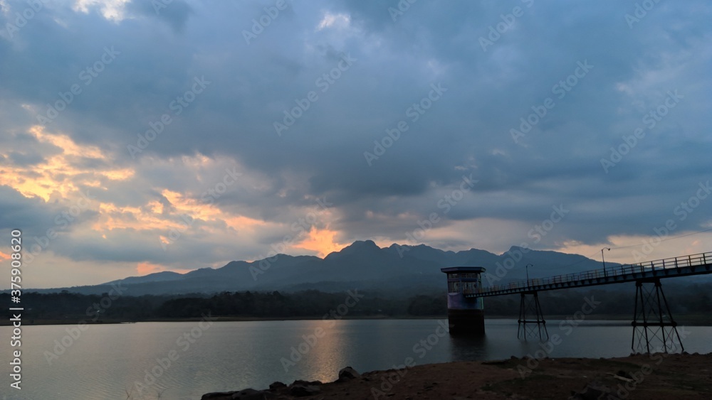The reservoir landscape when sunset and beautiful clouds, the middle bridge of the reservoir, the silhouette of muria mountains and cloudy skies
