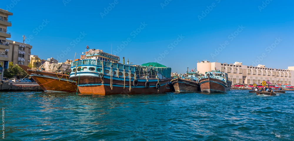 A view of moored dhow cargo vessels and Abra water taxis on the Dubai Creek in the UAE in springtime
