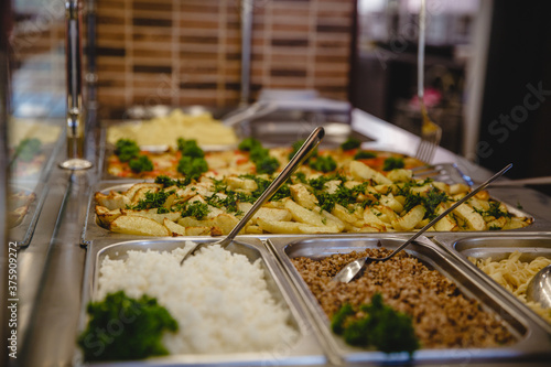 A variety of prepared dishes in containers in the dining room window. Public catering concept photo