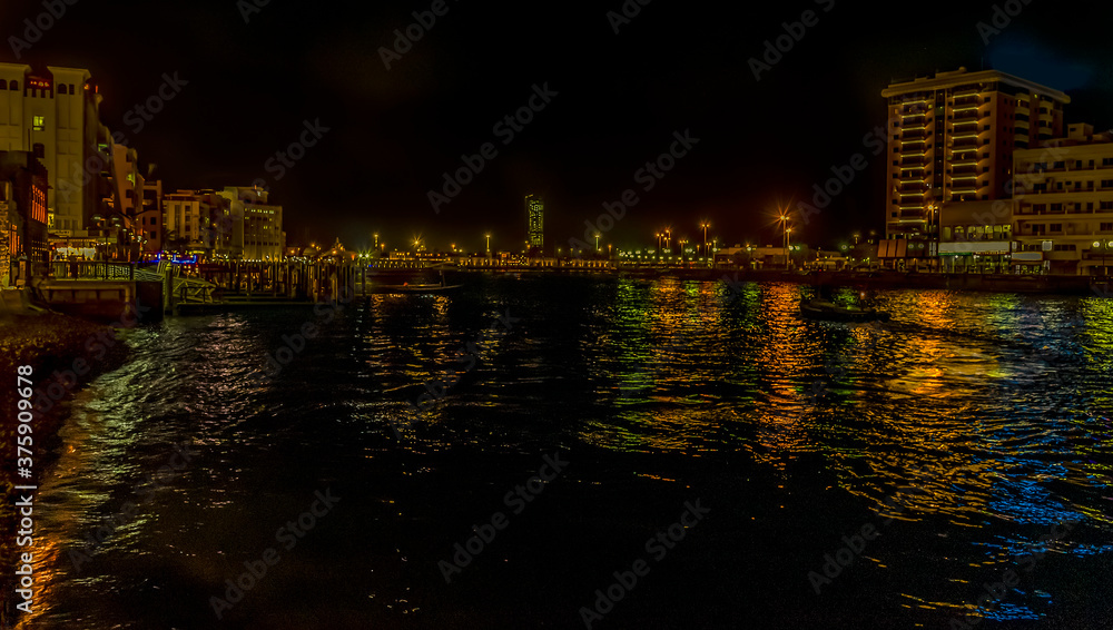 A view across the low reaches of the Dubai Creek at night in Dubai, UAE in springtime