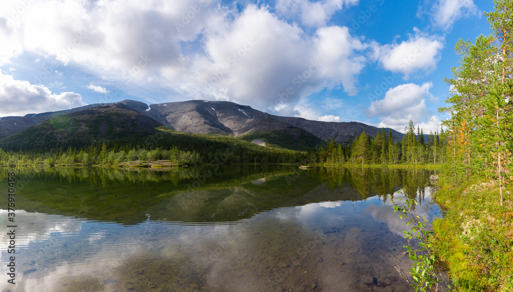 Panorama with a lake against the background of the mountain range and forest of the Khibiny mountains