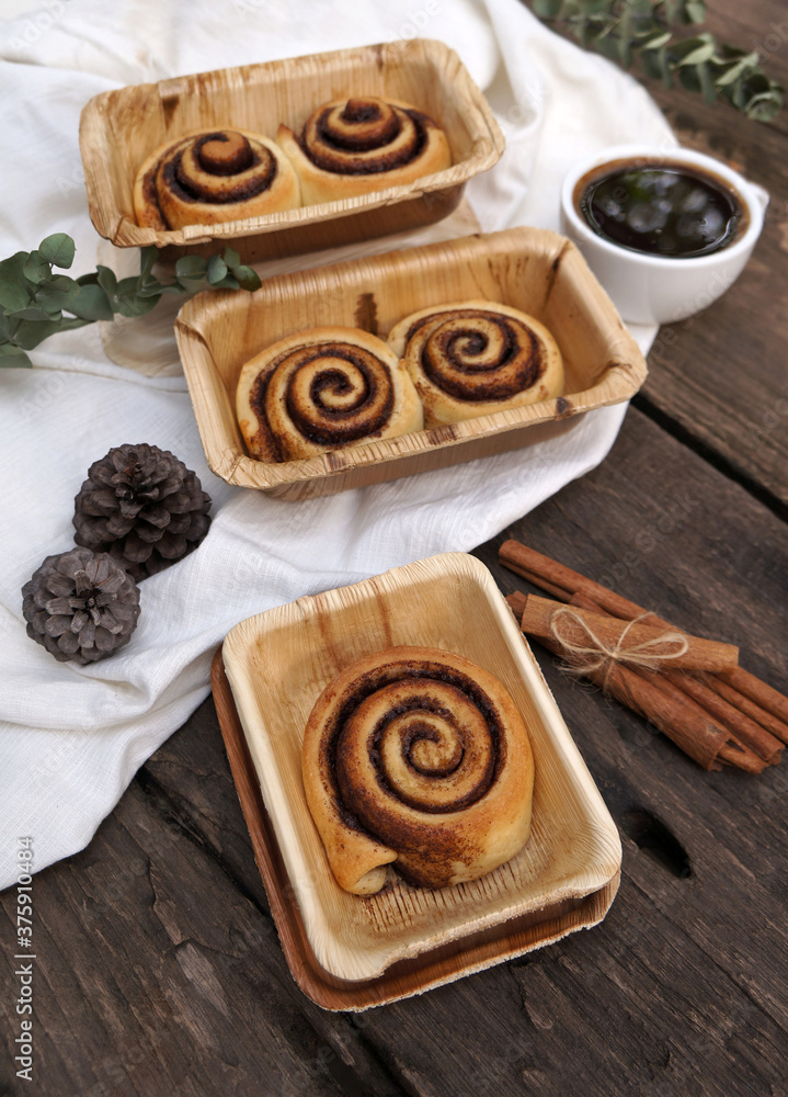Cinnamon rolls on a plate from nature on a wooden table.