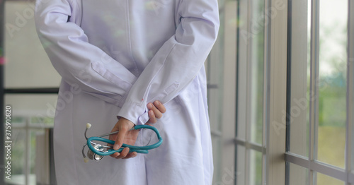 Female doctor holding a stethoscope by hand backside in a hospital close up view with copy space concept  an international hospital for healthcare service.