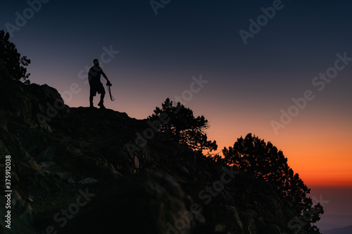 silhouette of a person with a camera on the top of a mountain at Troodos mountain in Cyprus