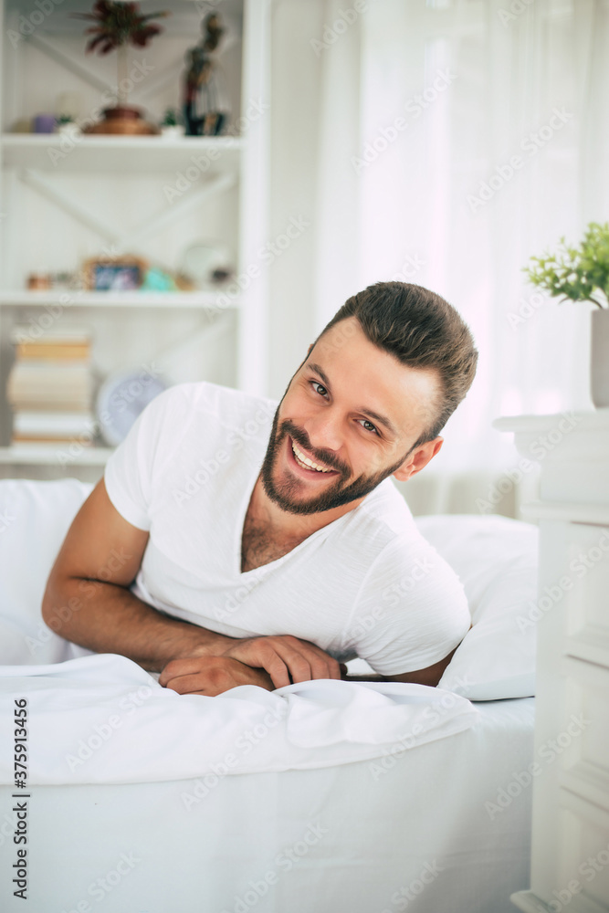 Close up photo of handsome young bearded man lying in bed and relaxing on the morning Close up photo of handsome young bearded man lying in bed and relaxing on the morning