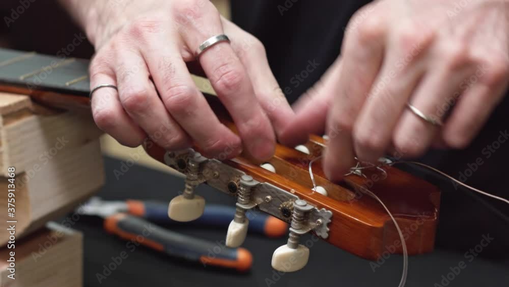 Caucasian luthier cleans guitar pegbox takes off strings cut with tool Caucasian luthier cleans guitar pegbox takes off strings cut with tool