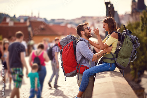 Young cheerful tourist couple at the city bridge