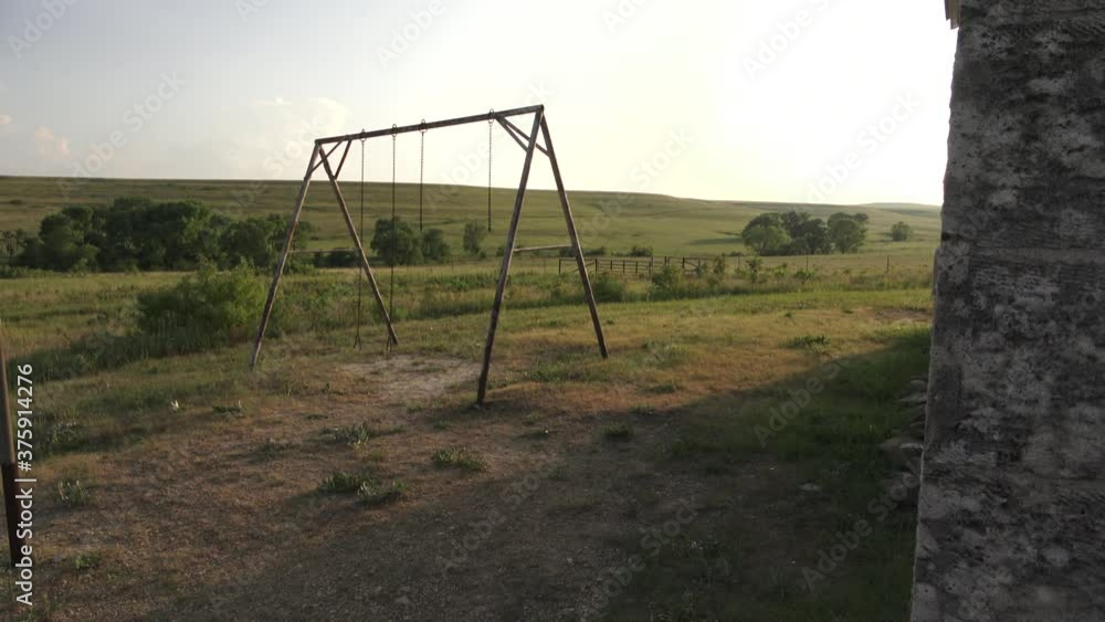 rusty swings sway in the breeze at an abandoned school in the open prairies of Kansas. rusty swings sway in the breeze at an abandoned school in the open prairies of Kansas.