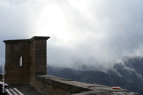 A small tower on the outer walls of the Hohenzollern castle in Germany, Europe. The view on the surrounding landscape and is hidden under the mist. 