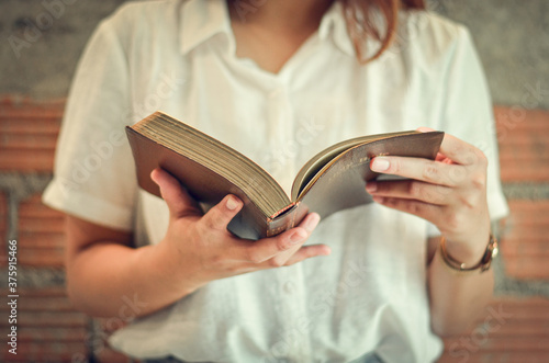 A young Christian woman closes her scriptures reading and studying in her room on Sunday.