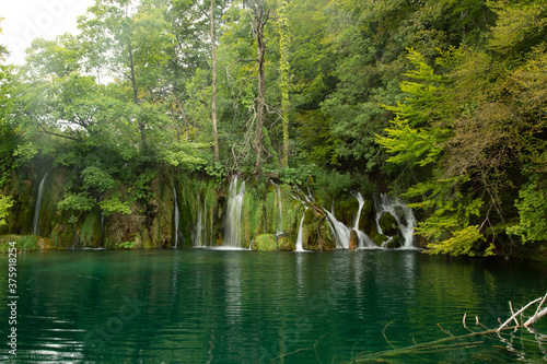 Lago de aguas verdes esmeralda con pequeñas cataratas